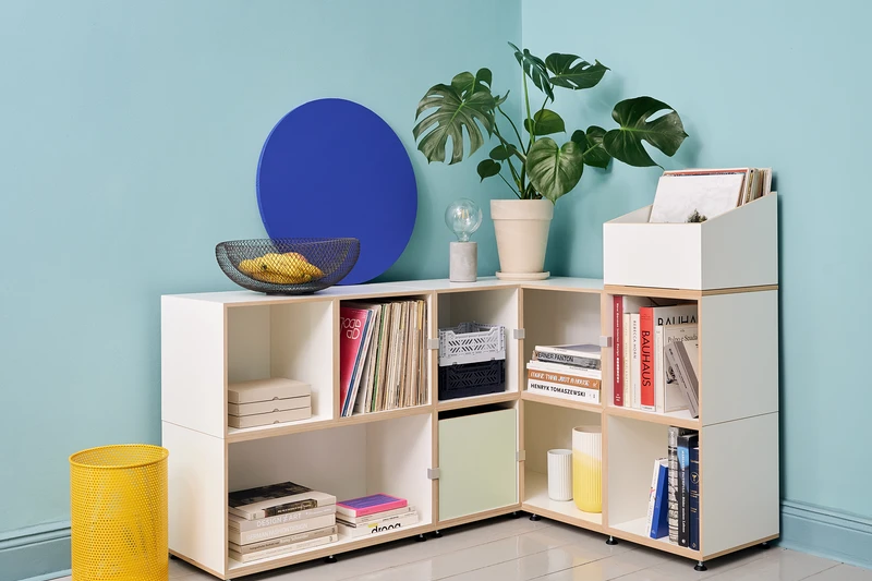 A large L-shaped stocubo corner shelving unit mixing records, books and decor around a room corner